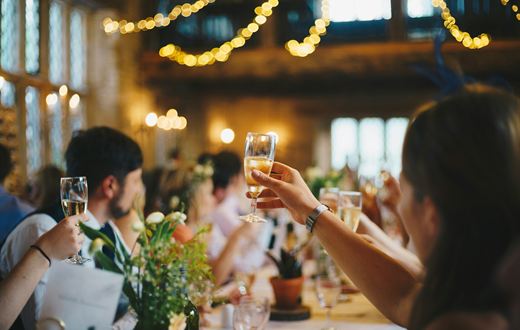 A couple toasting with sparkling wine at a candlelit table