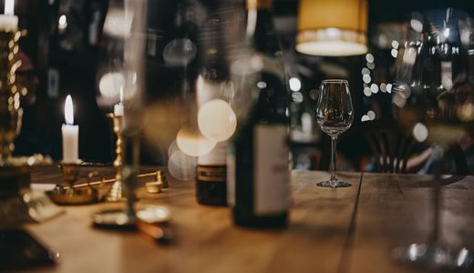 Wine bottles and a glass set out for a tasting