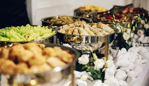Buffet trays of food laid out for a large gathering
