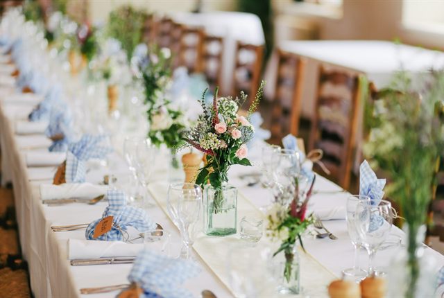 Wedding reception table laid with white flowers and glassware